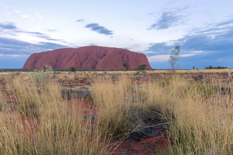 Uluru glowing red at sunset in the outback