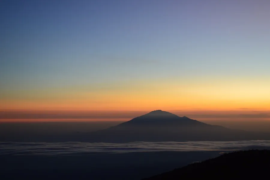 Mount Kilimanjaro rising above the clouds at dawn