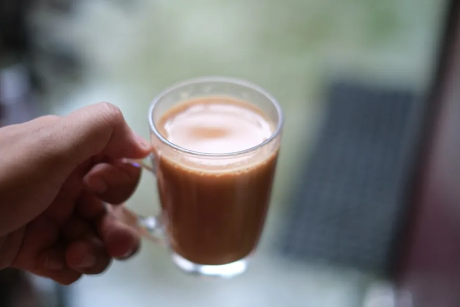 Hands holding a clay cup of masala chai